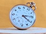 a pocket watch sitting on top of a piece of wood