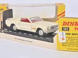 une petite voiture dans une boîte posée sur une surface blanche, avec une autre boîte à côté