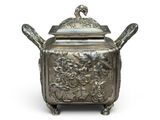 une théière ancienne en argent surmontée d'un oiseau