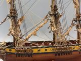 wooden model of a tall sailing ship on a white surface