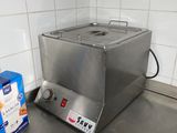 stainless steel counter top in a commercial kitchen with a fryer on it