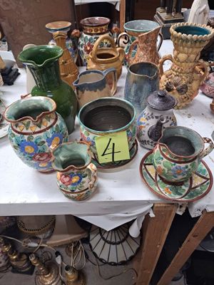 de nombreux vases et tasses posés sur une table, accompagnés d'une étiquette de prix