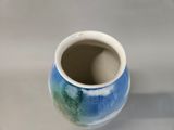 a blue and white vase sitting on a table