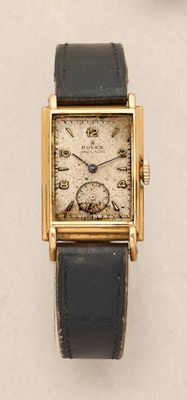 an image of a gold wrist watch with a black leather strap