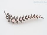 a close up of a brooch with pink stones on a white surface