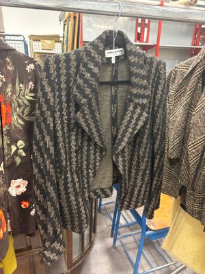 three jackets hanging on a rack in a store