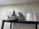 many pots and pans on a shelf in the kitchen