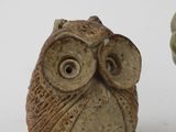 a small owl figurine next to a smaller owl figurine