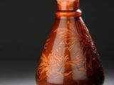 un vase marron posé sur une table sur fond noir