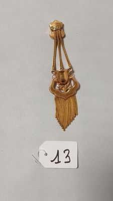 deux bijoux en or posés sur une surface blanche, accompagnés d'une étiquette de prix