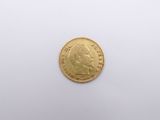 a gold coin on a white surface with a white background
