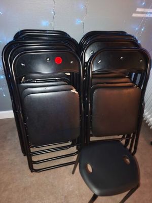 many black chairs in a room with a red button on the back