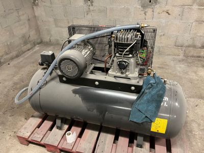 an air compressor sitting on a pallet in a room