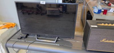 a television sitting on top of a table next to a speaker