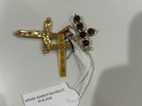 une croix en or ornée de grenats, à laquelle est attachée une étiquette de prix