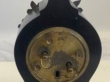 a black clock with a statue of a boy on top of it