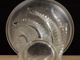 a glass vase with a fish on it on a table