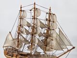 a wooden model of a sailboat on a table