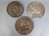 three different types of silver coins on a white surface