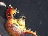 a teapot with a bird on it next to two cups
