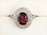 an image of a ring with a garnetite surrounded by diamonds
