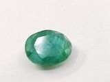 a close up of a green emerald stone on a white surface