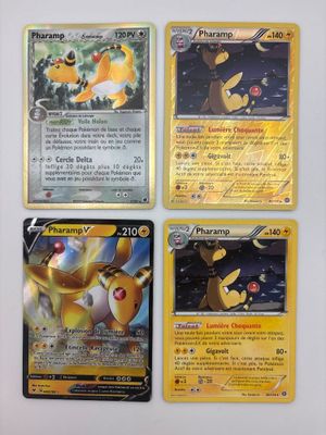 Quatre cartes Pokémon sont posées sur une table avec un fond blanc.