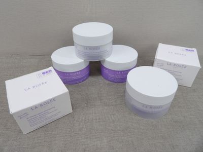 quatre pots de produits de soin posés sur une table