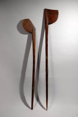 pair of wooden spoons on a white background with a shadow