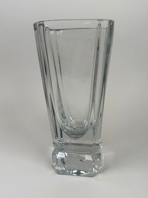 un vase en verre transparent posé sur une surface blanche