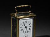une image représentant une petite horloge en laiton dont le cadran porte des chiffres romains