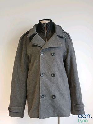 grey peale coat on a mannequin stand against a white wall