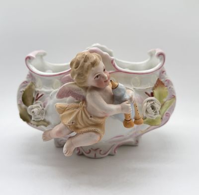 a figurine of a cupid playing a trumpet