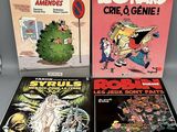 Trois bandes dessinées sont posées les unes à côté des autres sur une table.