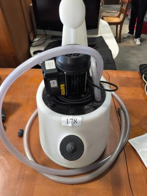 un aspirateur posé sur une table, muni d'un tuyau
