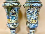 une paire de vases bleus et blancs ornés de personnages, posés sur une table