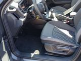 the interior of a car with the door open and the driver ' s seat down