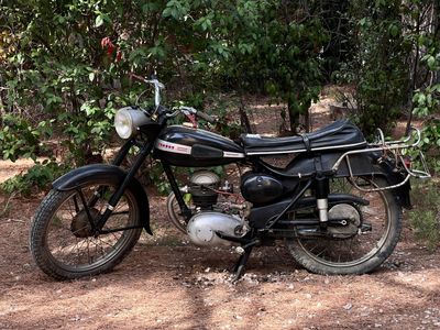 une moto noire garée sur la terre battue