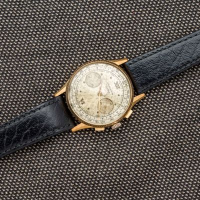 un gros plan d'une montre posée sur un tissu noir
