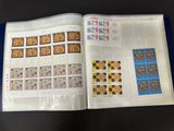un livre ouvert avec des timbres, posé sur une table