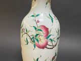 a white vase with a pink flower painted on it
