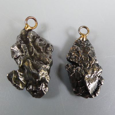On voit deux morceaux de métal posés sur une surface blanche