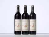 three bottles of red wine sitting on top of a table