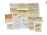 une image représentant une pile de vieux papiers posés sur une surface blanche