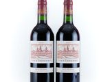 two bottles of red wine sitting next to each other on a white surface