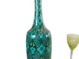 a green vase and a wine glass sitting next to each other