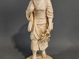 figurine en ivoire sculpté représentant une jeune fille avec un panier de fleurs