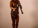 statue en bronze d'un garçon tenant une flûte, posée sur un socle