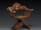 une chaise en bois dont le dossier et l'assise sont ornés de sculptures minutieuses