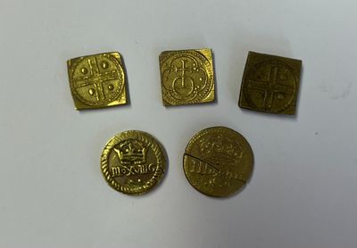 quatre pièces d'or posées sur une surface blanche